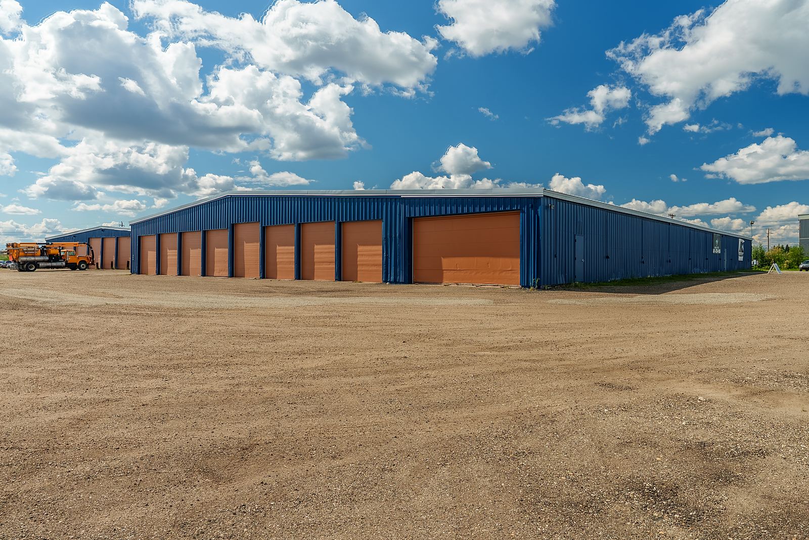 Blue warehouse with a row of gold overhead doors at 399 Helmericks Avenue